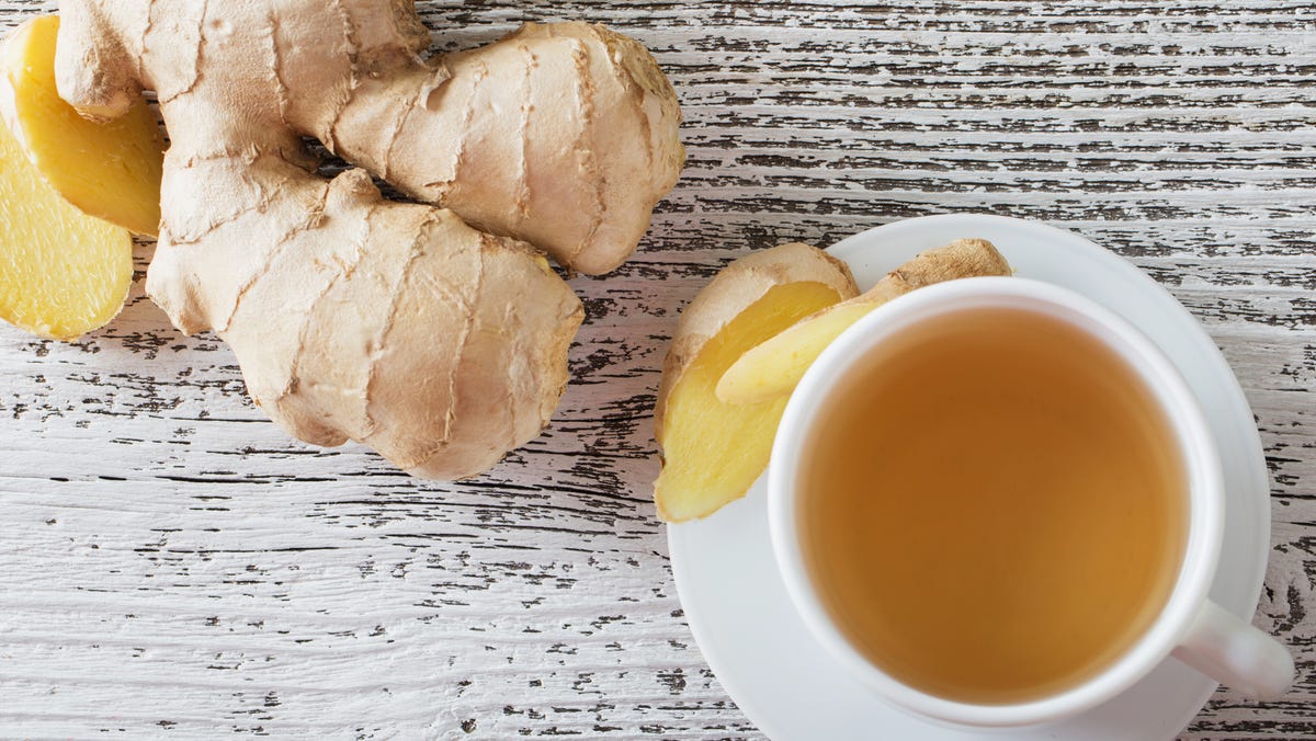 ginger tea in a white cup on wooden background royalty free image 492223016 1547048096